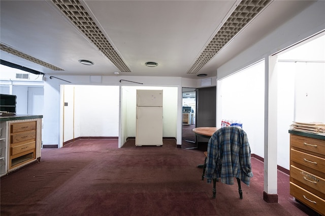 interior space featuring dark colored carpet and white refrigerator