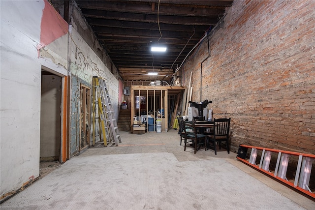 miscellaneous room featuring concrete floors and brick wall