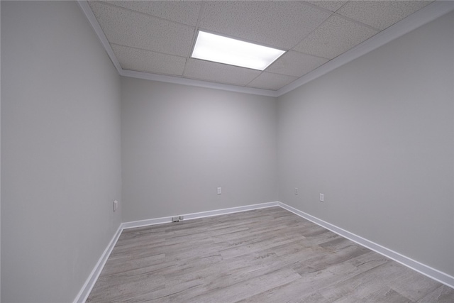 unfurnished room with a paneled ceiling and light wood-type flooring