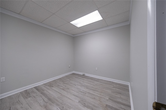 empty room featuring a paneled ceiling and light hardwood / wood-style floors