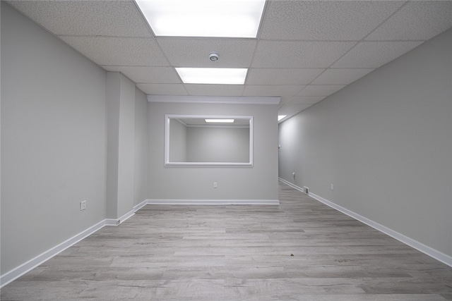 empty room with a paneled ceiling and light wood-type flooring