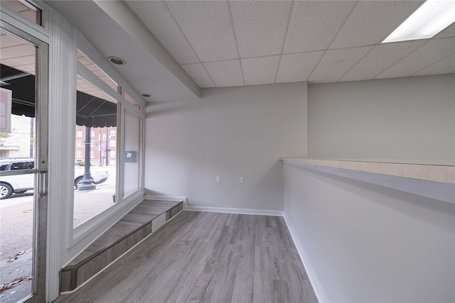 spare room featuring light hardwood / wood-style flooring and a paneled ceiling