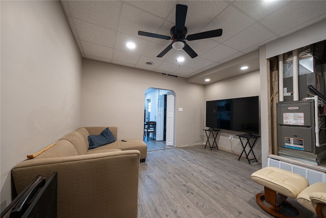 living room featuring ceiling fan, wood-type flooring, and a paneled ceiling