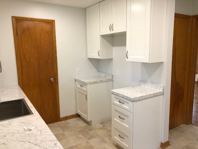 kitchen with white cabinets and light stone counters