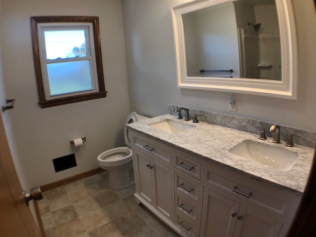 bathroom with vanity, a shower, and toilet