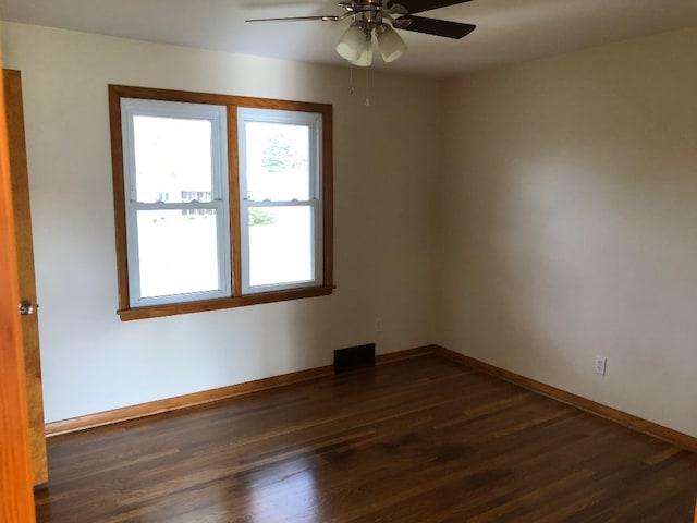 empty room featuring dark wood-type flooring and ceiling fan