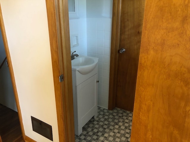 bathroom featuring vanity, tile patterned floors, and tile walls