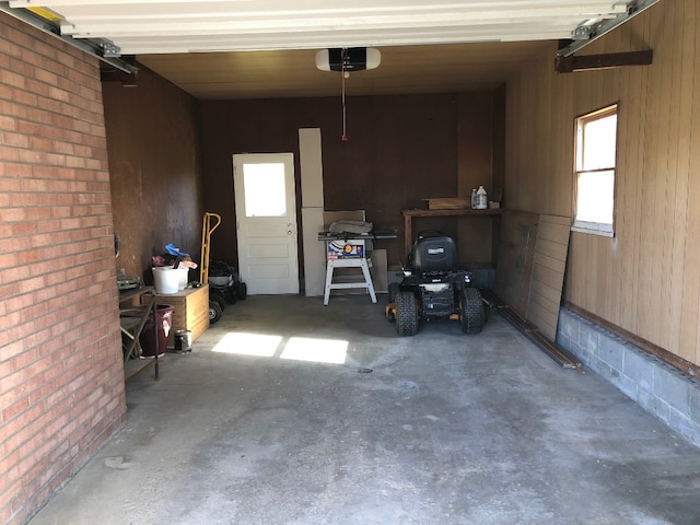 garage featuring a garage door opener and wood walls