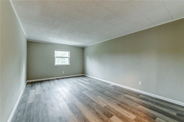 unfurnished room featuring wood finished floors and baseboards