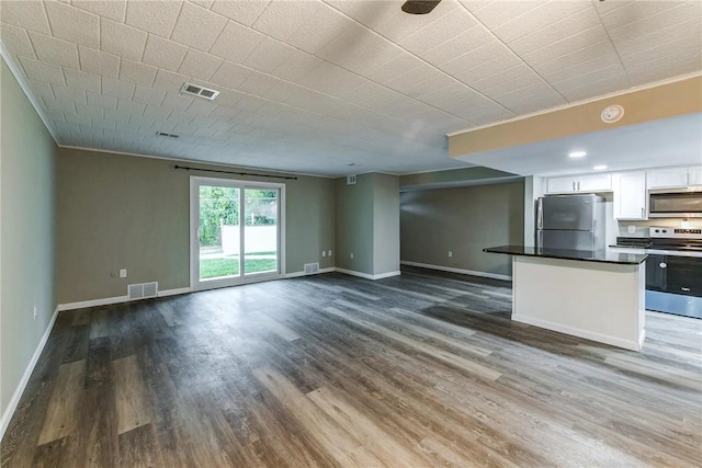 unfurnished living room with ornamental molding, visible vents, and dark wood-style flooring