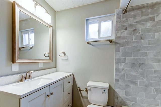 full bath featuring a wealth of natural light, toilet, a shower, and vanity