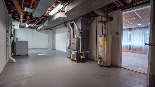 basement with water heater, heating unit, and washer / dryer