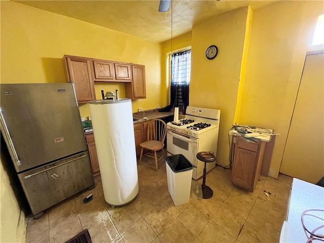 kitchen with stainless steel fridge, decorative light fixtures, and white gas range oven