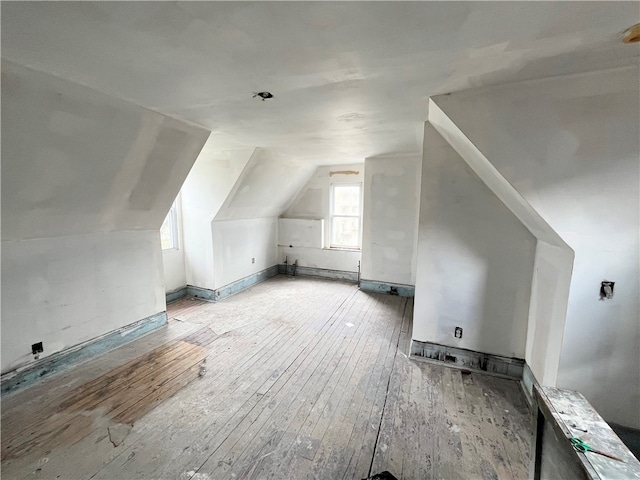 additional living space with lofted ceiling and light hardwood / wood-style flooring