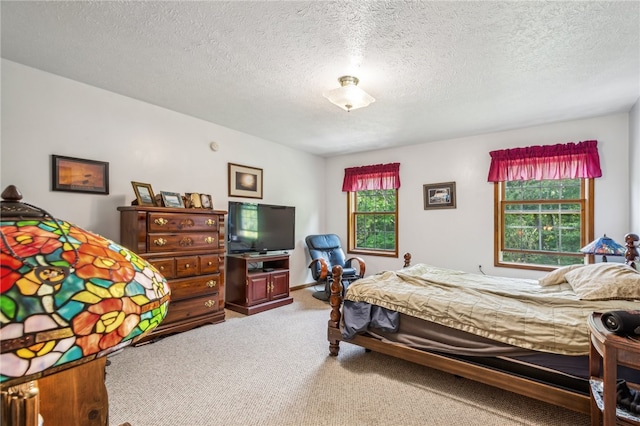 bedroom featuring a textured ceiling, multiple windows, and carpet floors