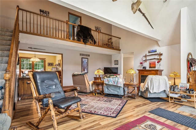 living area with a towering ceiling and hardwood / wood-style flooring