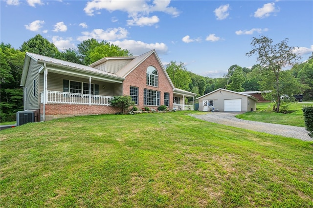 view of front facade with covered porch, a garage, a front lawn, and an outbuilding