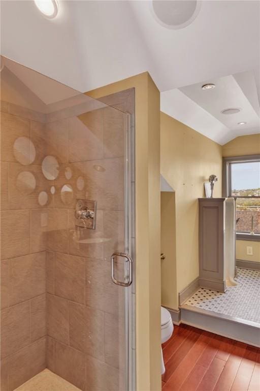 110 Pius St, South Side, PA 15203 - bathroom with wood finished floors, vaulted ceiling, toilet, a stall shower, and baseboards