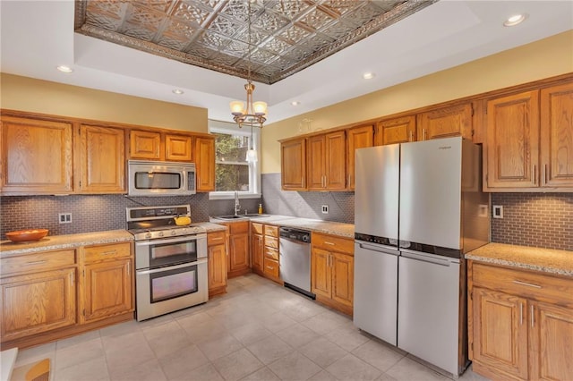 110 Pius St, South Side, PA 15203 - kitchen featuring stainless steel appliances, a raised ceiling, a sink, brown cabinetry, and backsplash
