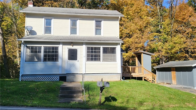 view of front property with a storage unit and a front yard