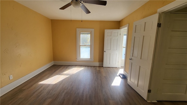 empty room featuring dark wood-type flooring and ceiling fan