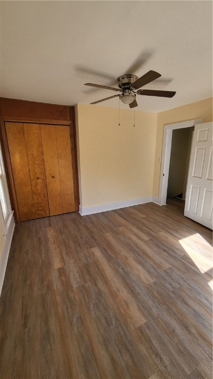 unfurnished bedroom featuring a closet, ceiling fan, and dark hardwood / wood-style flooring