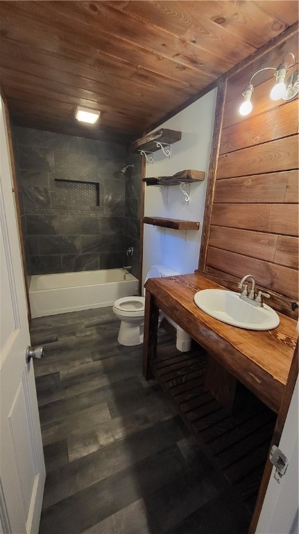 full bathroom with tiled shower / bath, hardwood / wood-style floors, wood ceiling, toilet, and sink