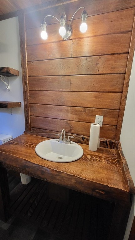 bathroom with vanity and wood walls