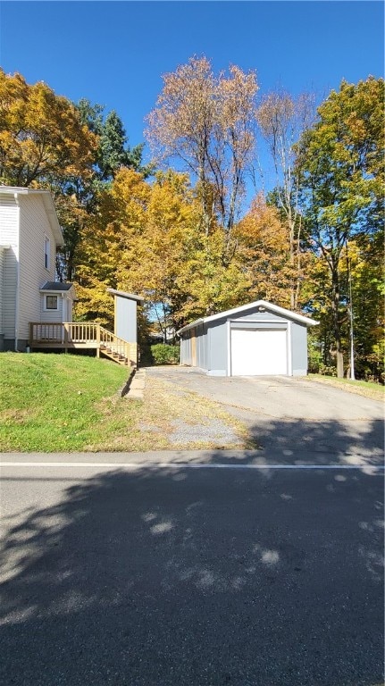 view of front facade featuring an outdoor structure, a garage, and a front lawn