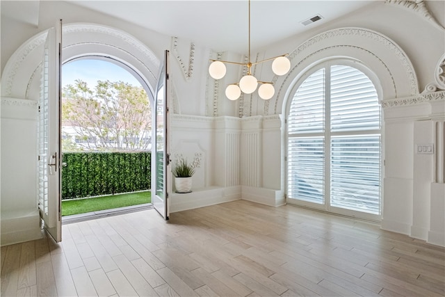 interior space with light hardwood / wood-style flooring and a notable chandelier