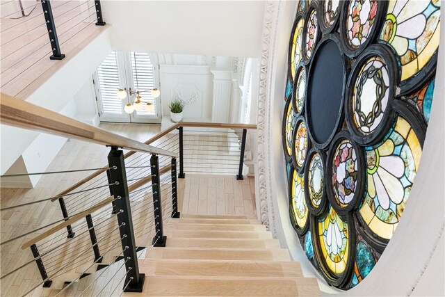 staircase with french doors and hardwood / wood-style flooring