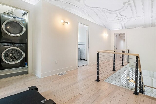 interior space featuring stacked washer / drying machine and light hardwood / wood-style floors