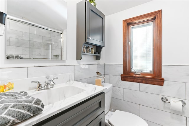 bathroom featuring tile walls, vanity, toilet, and walk in shower