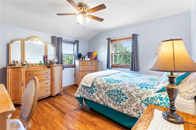 bedroom featuring light hardwood / wood-style flooring, multiple windows, lofted ceiling, and ceiling fan