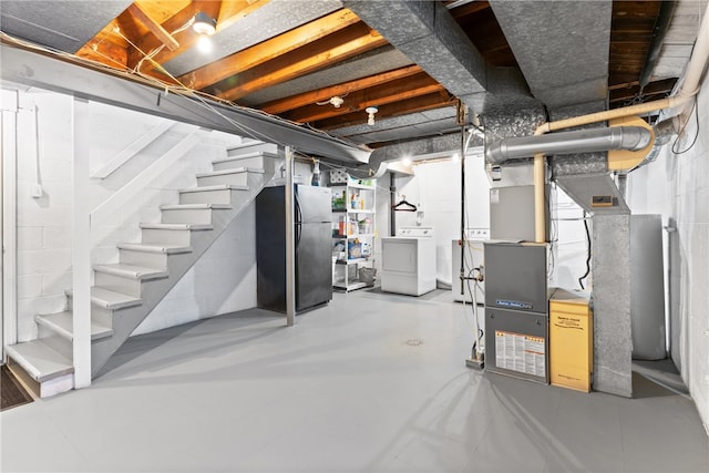 basement with separate washer and dryer and black fridge