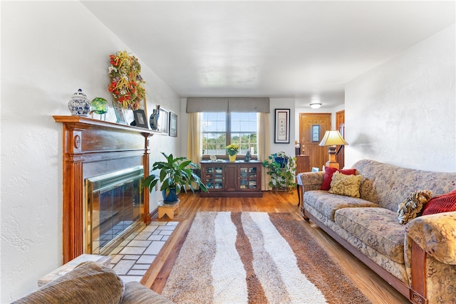 living room with light hardwood / wood-style flooring and a tile fireplace