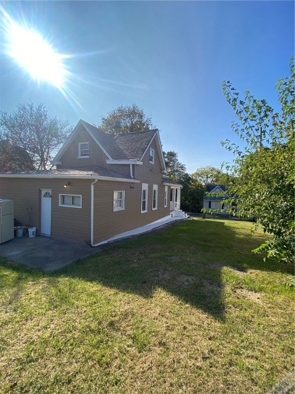 back of house with a patio area and a yard