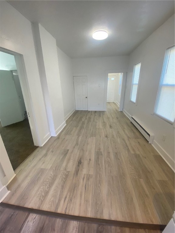 empty room featuring light hardwood / wood-style floors and a baseboard radiator