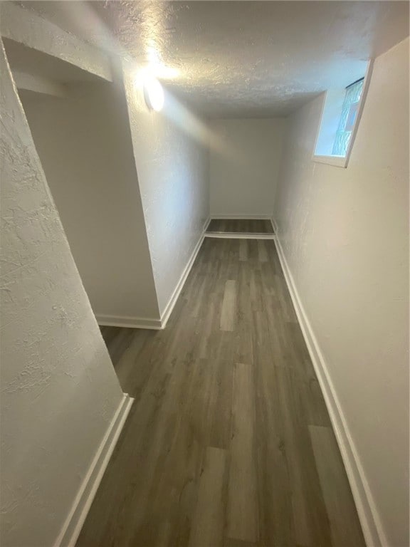 corridor featuring dark hardwood / wood-style flooring and a textured ceiling