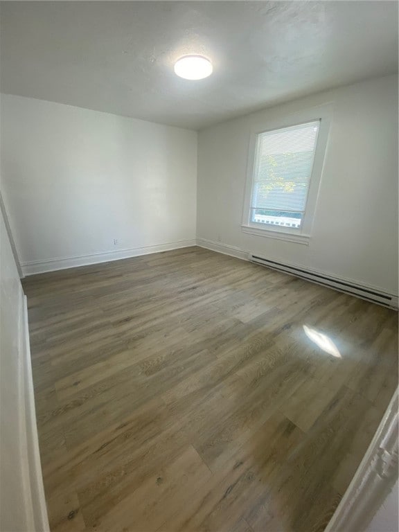 unfurnished room featuring a baseboard radiator and wood-type flooring