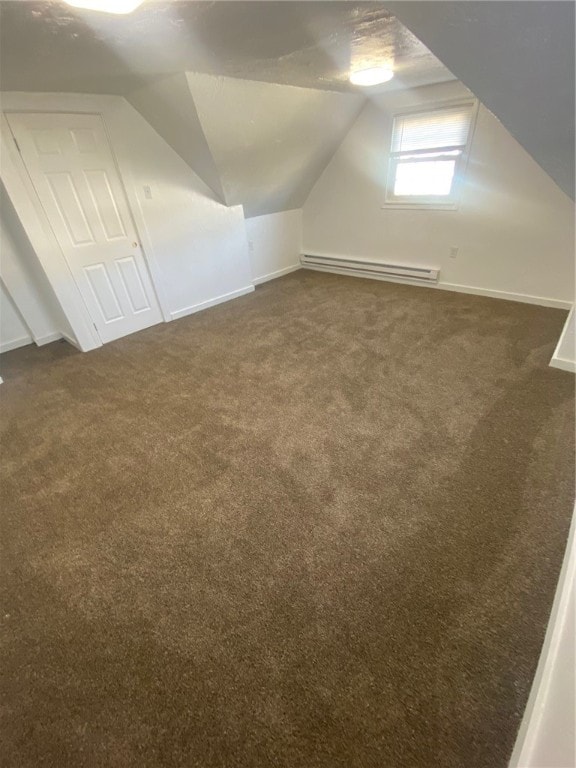 additional living space featuring a baseboard radiator, vaulted ceiling, and dark carpet