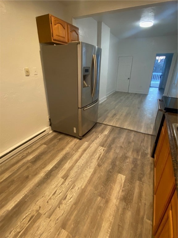 kitchen featuring stainless steel refrigerator with ice dispenser, a baseboard radiator, and light wood-type flooring