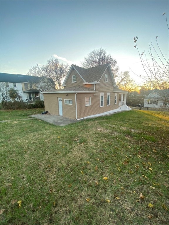 back of property featuring a lawn and a patio