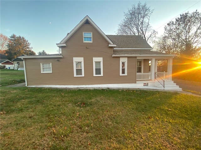 back of house with a porch and a lawn