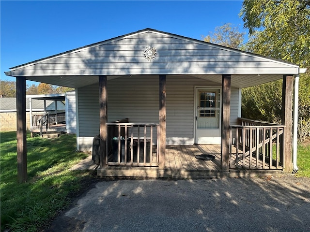 rear view of property with covered porch and a lawn