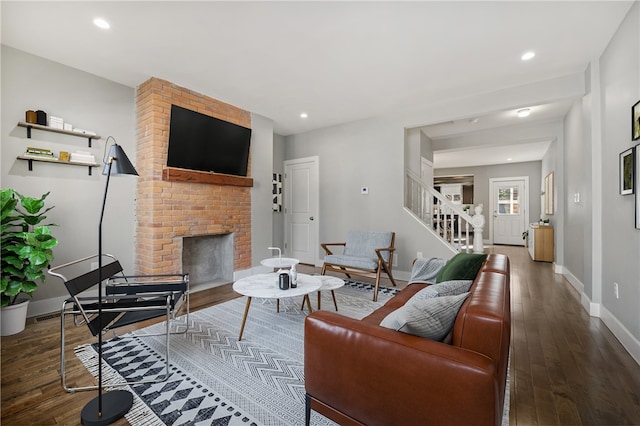 living room with dark wood-type flooring and a fireplace