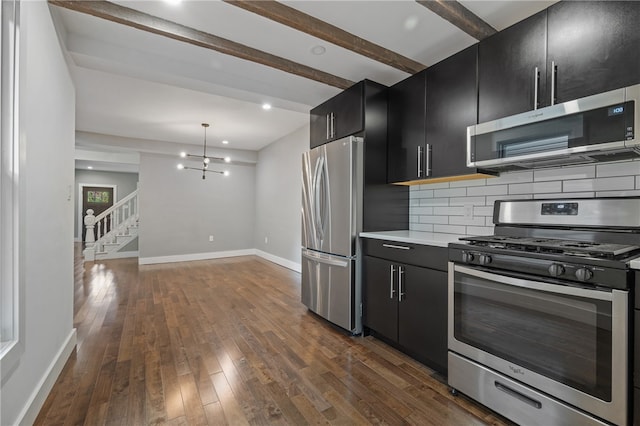 kitchen with dark hardwood / wood-style floors, stainless steel appliances, backsplash, a notable chandelier, and decorative light fixtures