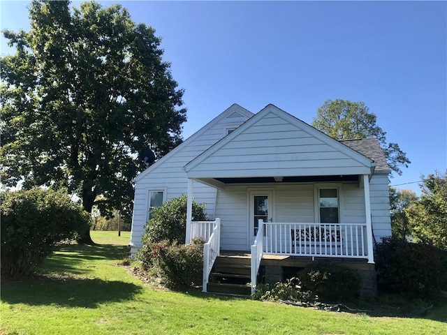 bungalow with a front yard and covered porch