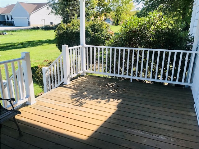 wooden deck featuring a lawn