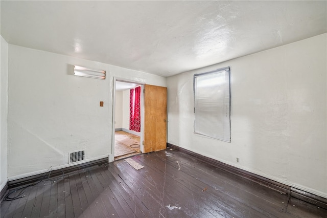 unfurnished room with dark hardwood / wood-style flooring